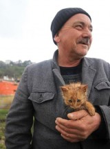 Taşkın bölgesinde ıslanan kedi yavrusunu ceketinde ısıttı